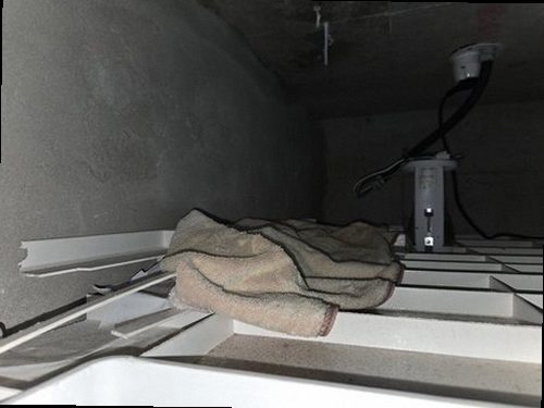 계양구 누수탐지 싱크대 주변 벽지 얼룩과 하부장 내부를 확인하는 모습